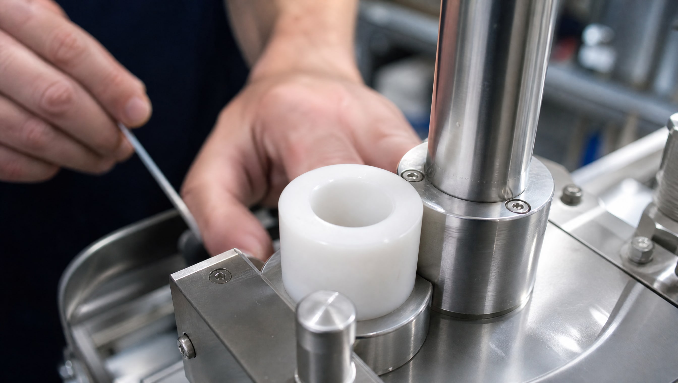 На макросъемке виден гладкий белый полимерный компонент PTFE в фармацевтическом механизме, демонстрирующий материалы для узлов трения.