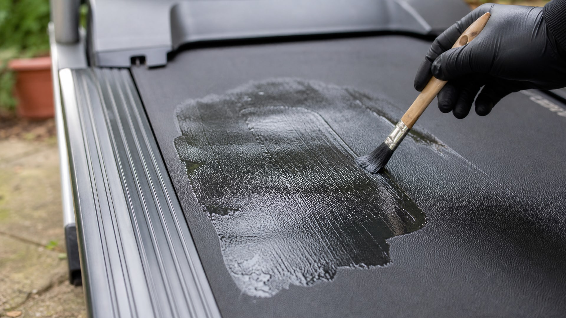 Тонкий слой силиконовой смазки равномерно распределен по поверхности черного полотна беговой дорожки.