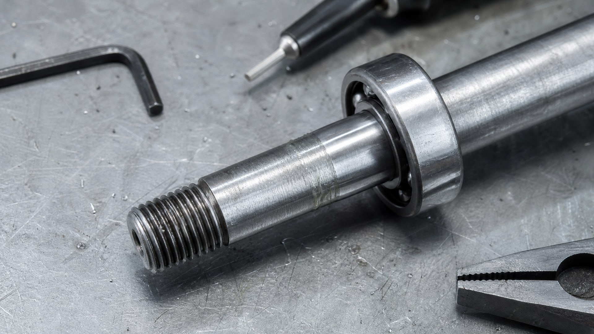 Подшипник аккуратно устанавливается на вал с видимым слоем фиксатора, вокруг разложены инструменты для фиксации.
