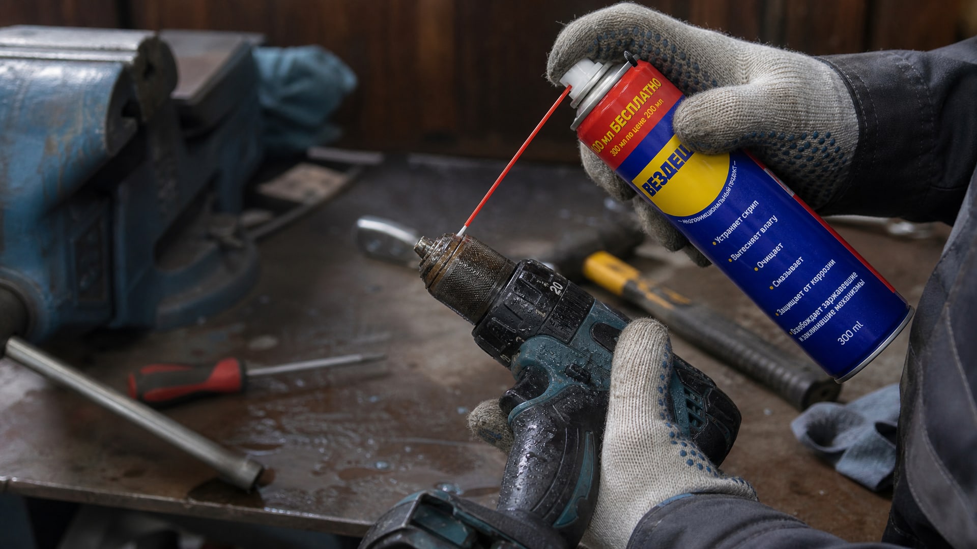 Рука в перчатке наносит универсальную смазку WD-40 на электроинструмент.